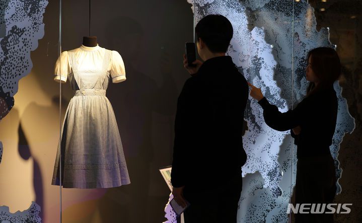 [대구=뉴시스] 이무열 기자 = 사진은 지난해 1월 12일 대구 달서구 이월드 83타워에서 열린 '뮤지컬 특별전: 라라의 꿈의 극장'을 찾은 관람객들이 영화 오즈의 마법사 도로시 드레스를 살펴보고 있는 모습.  202401.12. lmy@newsis.com