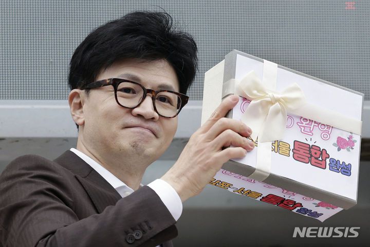 [김포=뉴시스] 최동준 기자 = 한동훈 국민의힘 비상대책위원장이 지난달 3일 경기 김포시 라베니체광장에서 김포검단시민연대 주최로 열린 '김포-서울 통합 GTX-D 노선안 환영 시민대회'에 참석해 전달받은 김포-서울 통합 염원 메시지를 들어 보이고 있다. 2024.02.03. photocdj@newsis.com