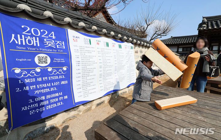 [서울=뉴시스] 권창회 기자 = 설날인 10일 오후 서울 중구 남산골한옥마을에서 열린 '청룡이 복 나르샤' 설축제에서 어린이가 윷을 던지고 있다. 2024.02.10. kch0523@newsis.com