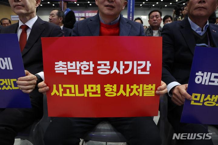 [수웓=뉴시스] 고승민 기자 = 지난 14일 경기 수원시 수원메쎄에서 열린 50인 미만 사업장 중대재해처벌법 유예 촉구 결의대회에서 참가자들이 피켓을 들고 있다. 2024.02.29. kkssmm99@newsis.com