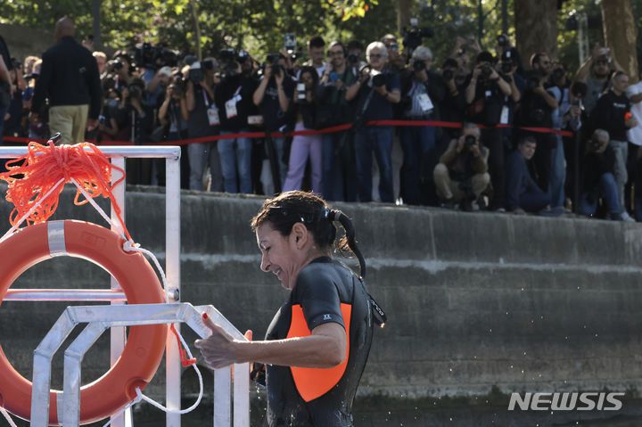 Paris Mayor Anne Hidalgo exits the Seine river after a swim, Wednesday, July 17, 2024 in Paris. After months of anticipation, Paris Mayor Anne Hidalgo took a dip in the Seine River on Wednesday, fulfilling a promise she made months ago to show the river is clean enough to host open-swimming competitions during the 2024 Olympics ? and the opening ceremony on the river nine days away.(Joel Saget, Pool via AP)