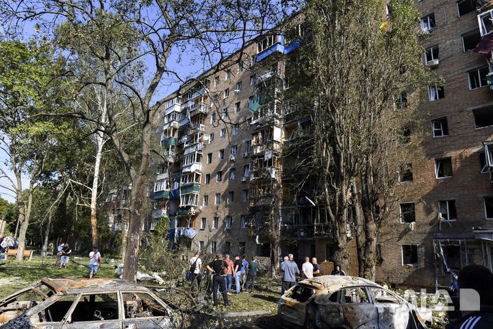 [쿠르스크=AP/뉴시스] 11일(현지시각) 러시아 쿠르스크 주민들이 우크라이나군의 공격으로 파손된 아파트 주변에 모여 있다.  2024.08.12.