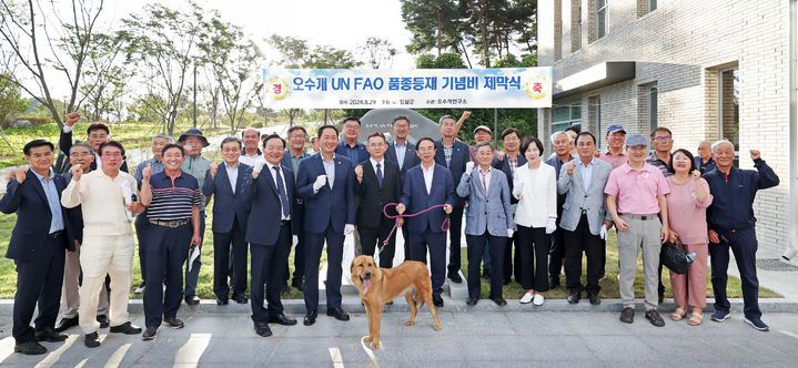 [임실=뉴시스] 지난해 8월29일 사람 살린 의견 '오수개'의 UN 식량농업기구(FAO) 품종 등재를 기념하는 임실군의 기념비 제막식에서 복원·육종된 오수개와 함께 심민 군수를 비롯한 관계자들이 기념사진을 찍고 있다. *재판매 및 DB 금지