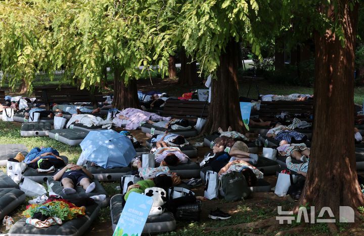 [서울=뉴시스] 이영환 기자 = 8일 오후 서울 송파구 올림픽공원 피크닉장에서 유한킴벌리가 주최한 2024 우리강산 푸르게 푸르게 숲속 꿀잠대회에서 참가자들이 잠을 청하고 있다.  유한킴벌리는 시민들이 도심의 숲속에서 휴식을 취하며 숲의 가치를 경험하고 숲 보호의 중요성까지 공감할 수 있도록 9년째 대회를 개최해 오고 있다. 2024.09.08. 20hwan@newsis.com