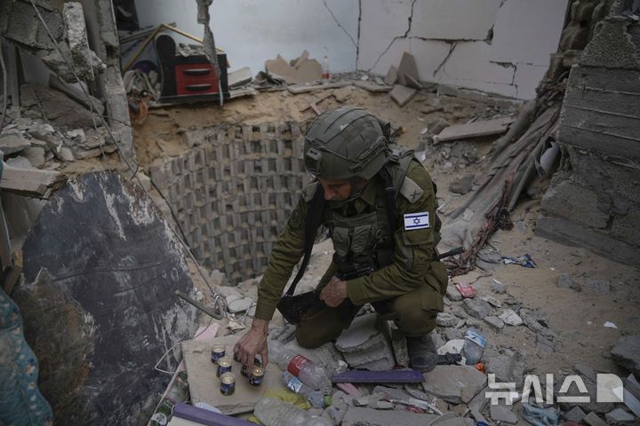 [가자지구=AP/뉴시스]  이스라엘군 대변인 다니엘 하가리 소장이 지난 해 9월 13일 이스라엘 인질 6명이 하마스에 살해된 가자지구 남부 땅굴 입구에 추모 촛불을 밝히고 있다. 2025.04.27.