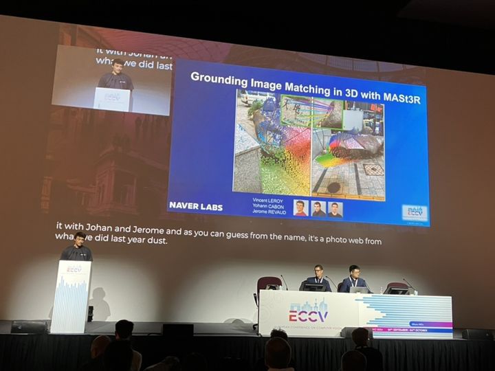 [서울=뉴시스] 네이버는 네이버랩스가 연구·발표한 공간지능 기술이 최근 열린 유럽컴퓨터비전학회(ECCV) 두 부문에서 1위를 차지했다고 8일 밝혔다. 지난달 28일부터 이탈리아 밀라노에서 진행된 ECCV 2024에서 네이버랩스 연구원들이 MAS3tR에 대해 발표하는 모습 (사진=네이버 제공) *재판매 및 DB 금지