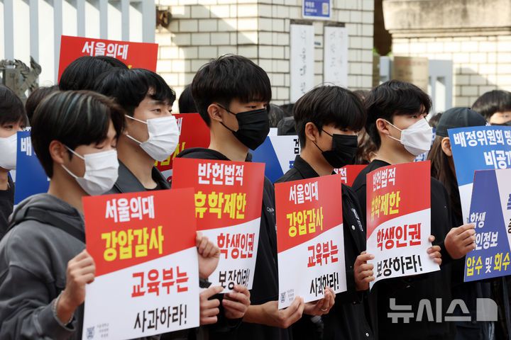 [서울=뉴시스] 김명년 기자 = 서울대학교 의과대학 학생들이 지난 21일 서울 종로구 서울대의대 앞에서 열린 ‘서울의대에 대한 교육부의 폭압적인 감사 규탄 집회’에서 피켓을 들고 침묵시위를 하고 있다. 2024.10.23. kmn@newsis.com