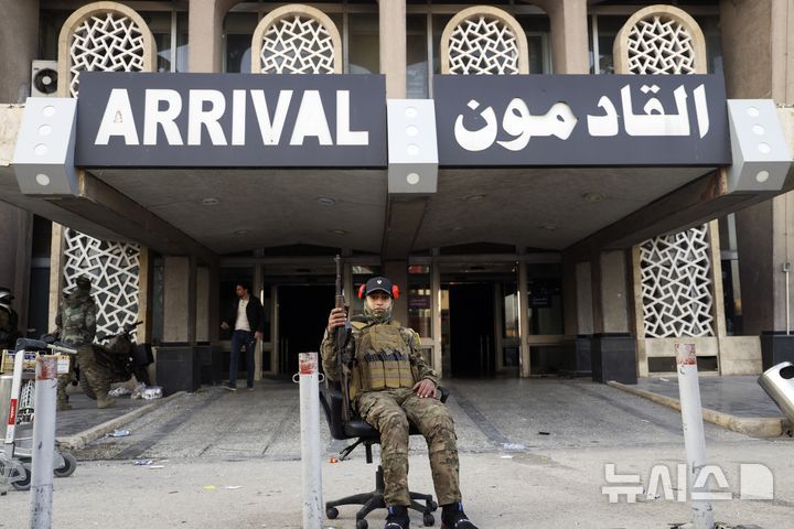 [알레포=AP/뉴시스] 12월 2일 시리아 알레포 국제공항을 점령한 시리아 반군 전투원이  의자에 앉아 기념사진을 찍고 있다. 2024.12.08.