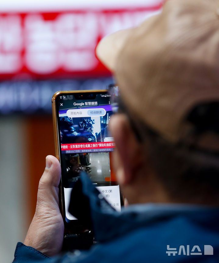 [제주=뉴시스] 우장호 기자 = 윤석열 대통령이 비상계엄을 선포한 지 6시간여 만에 해제한 4일 오전 제주국제공항 국제선 도착장 대합실에서 중화권 이용객들이 계엄 관련 뉴스를 시청하고 있다. 2024.12.04. woo1223@newsis.com