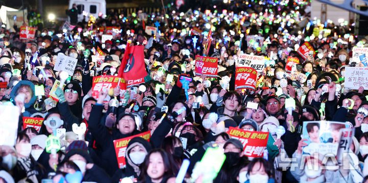 [서울=뉴시스] 전신 기자 = 8일 서울 여의도 국회 앞에서 열린 윤석열 대통령 탄핵을 촉구하는 촛불문화제에서 참가자들이 손팻말을 들고 윤 대통령 탄핵을 촉구하고 있다 2024.12.08. photo1006@newsis.com