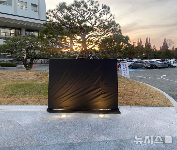 [창원=뉴시스]한국산업단지공단 경남지역본부 청사 앞에 설치되어 있는 윤석열 대통령 친필 표지석에 민주노총 경남본부에서 지난 10일 오후 대통령 윤석열 글자 앞에 검은색 스프레이로 '내란'을 추가했고, 표지석 소유자인 창원시에서는 11일 현재까지 표지석을 천으로 가려놓고 있다.(사진=독자 제공) 2024.12.11. photo@newsis.com