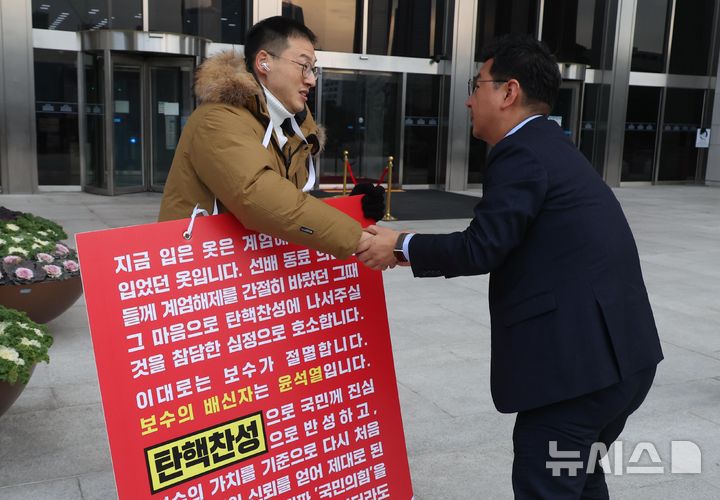 [서울=뉴시스] 조성봉 기자 = 김상욱 국민의힘 의원이 13일 오전 서울 여의도 국회 본청 입구에서 국민의힘 의원들에게 윤석열 대통령 탄핵 찬성 투표를 호소하는 1인 시위를 하던 중 김태선(오른쪽) 더불어민주당 의원의 격려를 받고 있다. 2024.12.13. suncho21@newsis.com