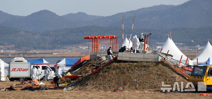 [무안=뉴시스] 김선웅 기자 = 2일 전남 무안국제공항 제주항공 여객기 참사 현장에서 항공·철도사고 조사위원회(ARAIB) 관계자들이 로컬라이저(방위각 표시 시설)가 설치된 콘크리트 둔덕을 조사하고 있다.  2025.01.02. mangusta@newsis.com