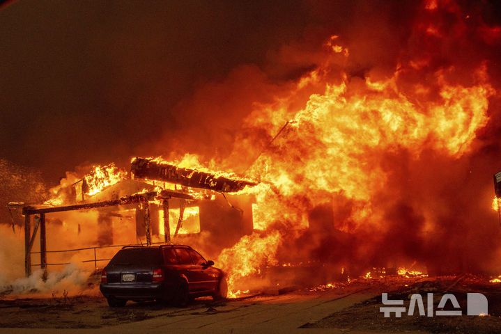 [이튼=AP/뉴시스]8일(현지시각) 미국 캘리포니아주 로스앤젤레스 이튼 지역에서 발생한 산불이 건물을 집어삼키고 있다. 2025.01.09.