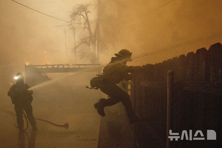 [알타데나=AP/뉴시스] 8일(현지시각) 미 캘리포니아주 알타데나에서 소방관들이 확산하는 '이튼 파이어' 산불을 진압하고 있다. 2025.01.09.