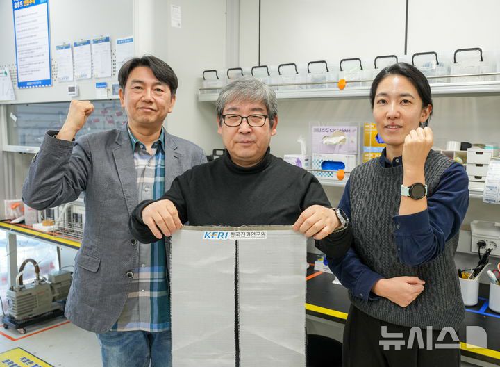 [창원=뉴시스]겨울철 전기차의 온돌형 난방 실현이 가능한 고효율 고유연 '금속섬유천 면상 발열체' 개발에 성공한 한국전기연구원(KERI) 이동윤 박사(가운데)와 연구팀이 포즈를 취하고 있다.(사진=한국전기연구원 제공) 2025.10.14. photo@newsis.com