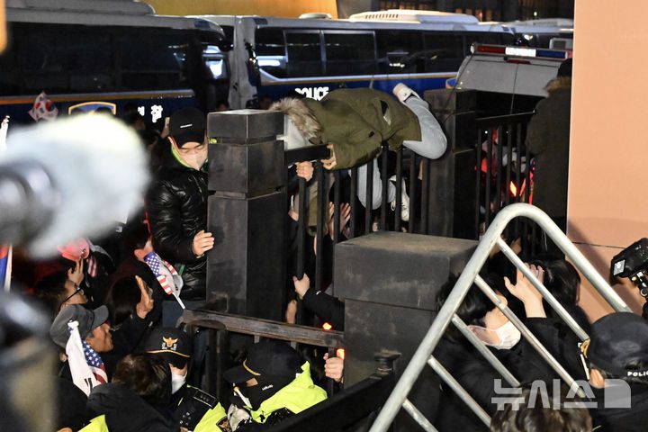 [서울=뉴시스] 김근수 기자 = 내란 수괴와 직권남용 등의 혐의를 받는 윤석열 대통령의 구속 전 피의자 심문(영장실질심사)이 열린 18일 서울 마포구 서울서부지방법원에서 윤 대통령 지지자들이 담장 너머에서 시위를 하고 있다. (공동취재) 2025.01.18. photo@newsis.com