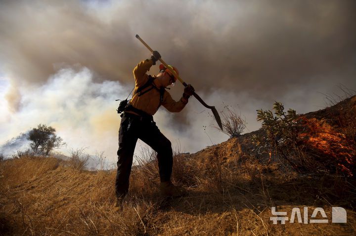 [캘리포니아주=AP/뉴시스] 22일(현지 시간) 미국 캘리포니아주 로스앤젤레스 캐스테익 인근에서 '휴즈 산불'이 발생해 소방대원이 화재 진압을 하고 있다. 2025.01.23.
