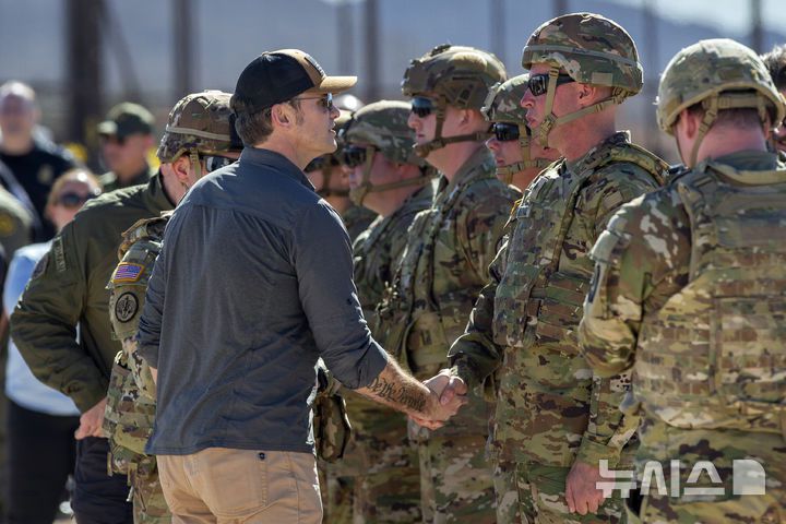 [선랜드파크=AP/뉴시스] 피트 헤그세스(왼쪽) 미국 국방장관이 3일(현지 시간) 뉴멕시코주 선랜드파크의 미-멕시코 국경을 방문해 장병들과 악수하고 있다. 2025.02.04.