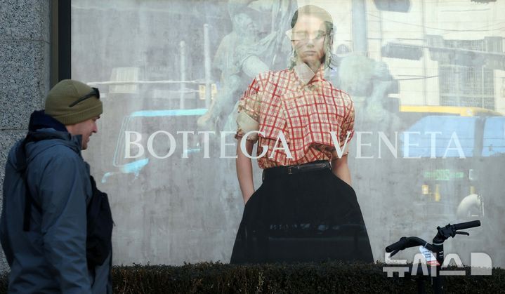 [서울=뉴시스] 고범준 기자 = 4일 한 시민이 서울의 한 백화점 앞에 설치된 보테가베네타 광고판 앞으로 지나가고 있다. 명품 브랜드 보테가베네타(Bottega Veneta)는 일부 가방 및 지갑 제품 중심으로 약 10% 가격을 올린다고 밝혔다. 2025.02.04. bjko@newsis.com