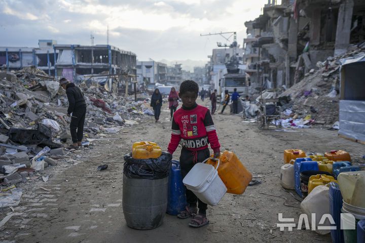 [가자시티=AP/뉴시스] 5일(현지 시간) 이스라엘군 공습과 지상 공격으로 크게 파괴된 가자지구 가자시티에서 한 어린이가 빈 물통들을 들고 물 받으러 가고 있다. 2025.02.06.