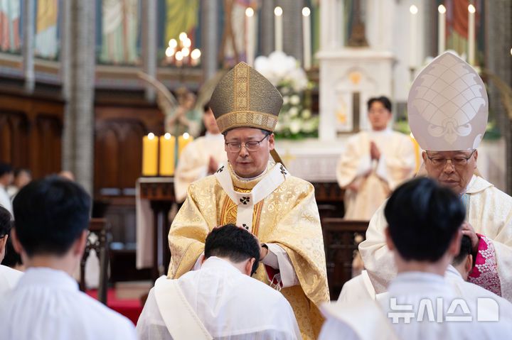 [서울=뉴시스] 사진공동취재단 = 천주교 서울대교구가 서울 중구 명동대성당에서 사제 서품식을 거행한 7일 신임 사제들이 교구장 정순택 대주교 등 관구 소속 사제단으로부터 안수기도를 받고 있다. 부제 26명이 이날 성품성사를 받고 사제 품계를 받았다. 2025.02.07. photo@newsis.com