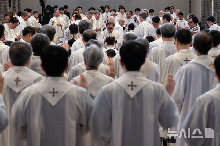 [서울=뉴시스] 사진공동취재단 = 천주교 서울대교구가 서울 중구 명동대성당에서 사제 서품식을 거행한 7일 신임 사제들이 교구장 정순택 대주교 등 관구 소속 사제단으로부터 안수기도를 받고 있다. 부제 26명이 이날 성품성사를 받고 사제 품계를 받았다. 2025.02.07. photo@newsis.com