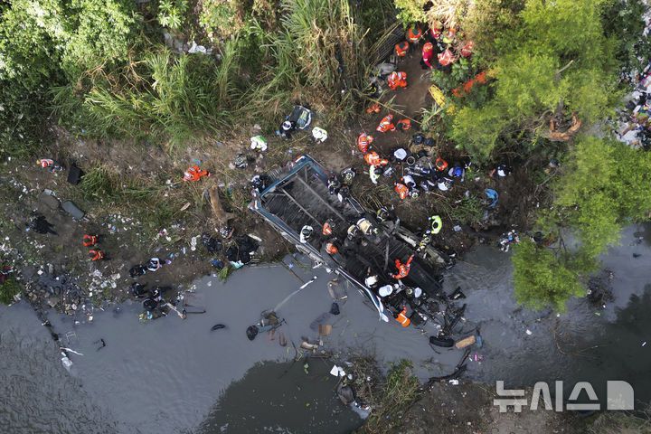 [과테말라시티=AP/뉴시스] 10일(현지 시간) 과테말라 수도 과테말라시티 외곽 버스 추락 현장에서 소방구조대가 희생자 시신을 옮기고 있다. 이날 새벽 70여 명이 탑승한 버스가 다리를 지나다가 수십 미터 아래 하천으로 추락해 지금까지 51명이 숨진 것으로 알려졌다. 2025.02.11.
