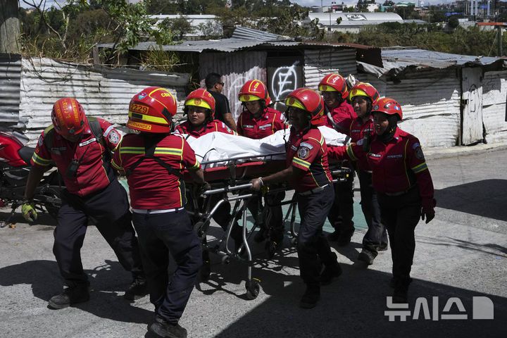 [과테말라시티=AP/뉴시스] 10일(현지 시간) 과테말라 수도 과테말라시티 외곽 버스 추락 현장에서 소방구조대가 희생자 시신을 옮기고 있다. 이날 새벽 70여 명이 탑승한 버스가 다리를 지나다가 수십 미터 아래 하천으로 추락해 지금까지 51명이 숨진 것으로 알려졌다. 2025.02.11.