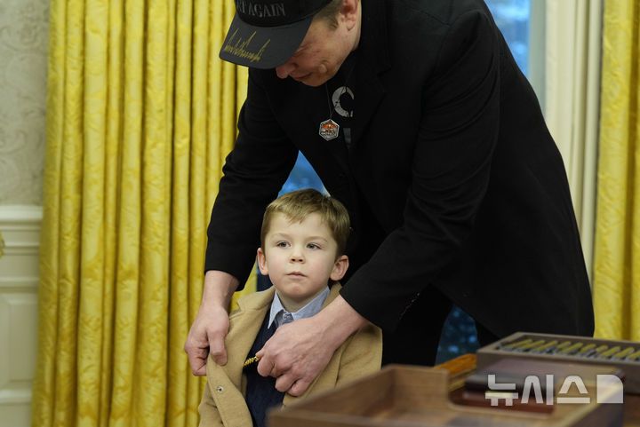 [워싱턴=AP/뉴시스] 일론 머스크가 11일(현지 시간) 워싱턴DC 백악관 대통령 집무실에서 아들 엑스 애쉬 에이 트웰브(X Æ A-Xii)의 옷매무새를 정리하고 있다. 2025.02.12.