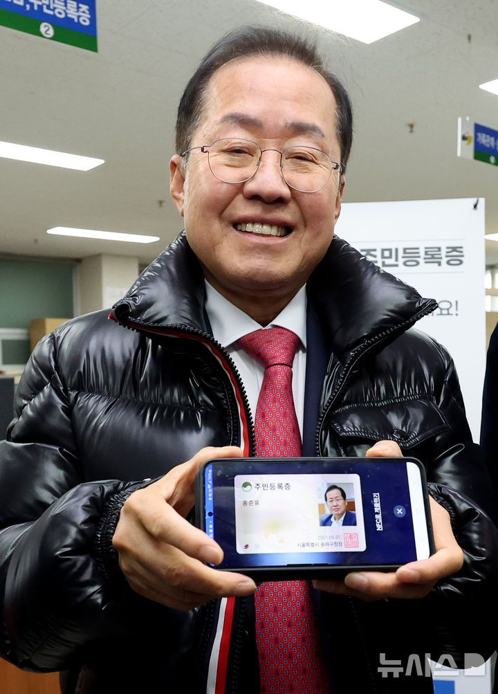 [대구=뉴시스] 이무열 기자 = 홍준표 대구시장이 14일 오전 대구 남구 봉덕2동 행정복지센터에서 발급받은 모바일 주민등록증을 들어 보이고 있다. 모바일 주민등록증 발급지역은 다음 달 14일 까지 전국으로 단계적으로 확대한다. 2025.02.14. lmy@newsis.com