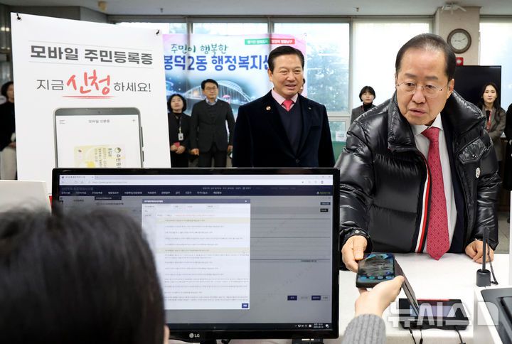 [대구=뉴시스] 이무열 기자 = 홍준표 대구시장이 14일 오전 대구 남구 봉덕2동 행정복지센터에서 모바일 주민등록증발급을 신청하고 있다. 모바일 주민등록증 발급지역은 다음 달 14일 까지 전국으로 단계적으로 확대한다. 2025.02.14. lmy@newsis.com