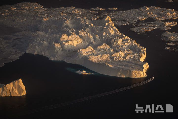 [일루리사트=AP/뉴시스] 지난 2월 18일(현지 시간) 그린란드 일루리사트에서 배 한 척이 거대한 빙산 옆을 항해하고 있다. 도널드 트럼프 미국 대통령이 그린란드에 야욕을 거침없이 드러내는 가운데, 미국과 덴마크 외교장관이 오는 3일 첫 회동하는 것으로 알려졌다. 2025.04.01.