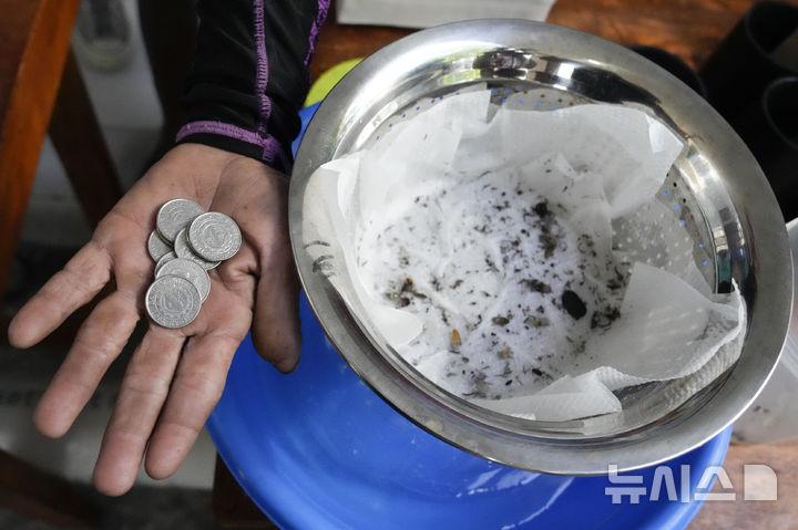 [만달루용=AP/뉴시스] 19일(현지 시간) 필리핀 마닐라 서부 만달루용의 한 마을에서 이곳 주민이 모기 유충 45마리를 잡아 포상금으로 받은 9페소를 보여주고 있다. 이 지역에서는 뎅기열 확산을 막기 위해 누구든 모기를 잡아 오는 사람에게 모기나 유충의 생사에 상관없이 5마리당 1페소(한화 약 25원)의 포상금을 지급한다. 마을 이장은 학생 2명이 뎅기열로 사망하자 이 같은 제도를 시행하게 됐다고 밝혔다. 2025.02.19.