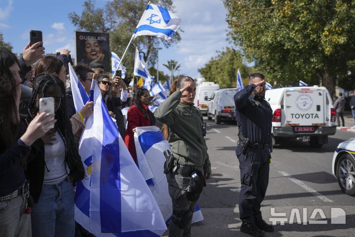 [텔아비브=AP/뉴시스] 가자지구에서 하마스가 넘긴 이스라엘 인질 시신 4구를 실은 차량 행렬이 20일(현지 시간) 이스라엘 텔아비브의 아부 카비르 법의학 연구소로 향하는 동안 이스라엘 국경 경비대원들이 거수경례로 애도하고 있다. 이스라엘 당국은 유전자 검사 결과 시신 4구 중 1구의 신원이 확인되지 않았다며 하마스가 휴전협정을 위반했다고 비난했다. 2025.03.23.
