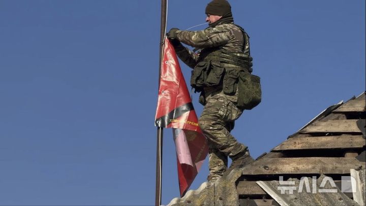 [쿠르스크=AP/뉴시스] 지난 3월 17일(현지 시간) 러시아 쿠르스크주 수드자 지역 스타랴야 소로치마 마을에서 러시아군 병사가 한 가정집 지붕에 부대 깃발을 걸고 있다. 2025.05.26.