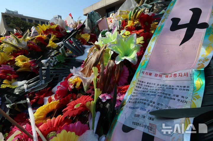 [서울=뉴시스] 이영환 기자 = 윤석열 대통령 탄핵심판 선고가 예상보다 늦어지고 있는 19일 오전 서울 종로구 헌법재판소 앞에 윤 대통령 지지자들이 보낸 화환이 놓여 있다.헌법재판소 사무처장이 지난 달 26일까지 자진 정비를 요청하며 적치물 정비 예고통지서를 부착했지만 화환은 방치되고 있다. 2025.03.19. 20hwan@newsis.com