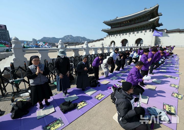 [서울=뉴시스] 고범준 기자 = 10.29 이태원 참사 유가족협의회, 시민대책회의 관계자들이 19일 서울 종로구 광화문 월대 옆에서 윤석열 대통령 파면 기원 159배를 하고 있다. 2025.03.19. bjko@newsis.com