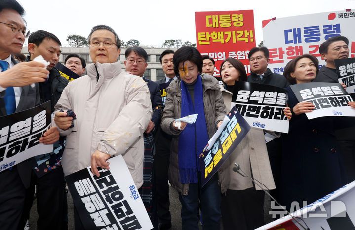 [서울=뉴시스] 홍효식 기자 = 백혜련 더불어민주당 의원이 20일 오전 서울 종로구 헌법재판소 앞에서 열린 내란수괴 윤석열 신속파면 촉구 기자회견 도중 탄핵 반대 시위자가 던진 계란을 맞은 뒤 손수건을 들고 있다. 2025.03.20. yesphoto@newsis.com