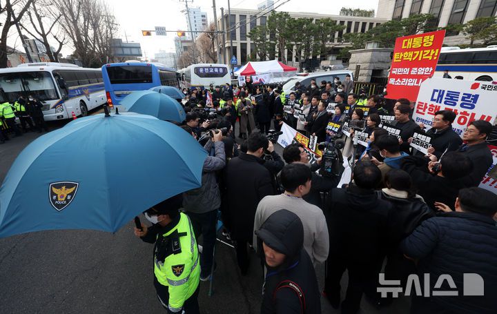 [서울=뉴시스] 홍효식 기자 = 20일 오전 서울 종로구 헌법재판소 앞에서 더불어민주당과 국민의힘 의원들이 탄핵 찬반의 시위 및 기자회견을 하고 있는 가운데 탄핵 반대 시위자의 음식물 투척을 막기 위해 경찰들이 우산을 펼쳐들고 있다. 2025.03.20. yesphoto@newsis.com