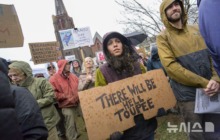[버몬트주=AP/뉴시스] 5일(현지 시간) 미국 버몬트주 브래틀보로의 한 교회에서 도널드 트럼프 대통령과 일론 머스크 정부효율부 수장에 반대하는 '핸즈 오프!'(Hands Off!) 집회가 열려 참가자들이 팻말을 들고 있다. 이날 미국 전역에서 손을 떼라는 의미의 '핸즈 오프' 시위와 행진이 열려 시민권 단체, 노동조합, 성소수자 권익 옹호 단체와 참전용사 단체 등이 참여했다. 2025.04.06.