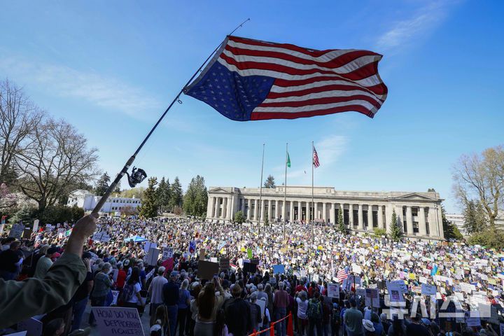 [올림피아=AP/뉴시스] 5일(현지 시간) 미 워싱턴주 올림피아에 있는 주의사당 앞에서 도널드 트럼프 대통령과 일론 머스크 정부효율부 수장에 반대하는 '핸즈 오프!'(Hands Off!) 집회가 열려 한 참가자가 뒤집힌 성조기를 흔들고 있다. 참가자들은 "제거하고, 되돌리고, 되찾자!"(Remove, Reverse, Reclaim)를 외치며 시위에 참여했다. 이날 미국 전역에서 손을 떼라는 의미의 '핸즈 오프' 시위와 행진이 열려 민권 단체, 노동조합, 성소수자 권익 옹호 단체와 참전용사 단체 등이 참여했다. 2025.04.06.