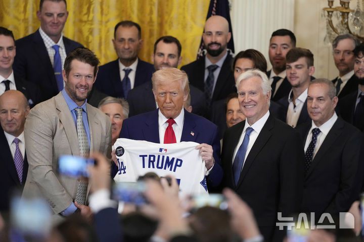 [워싱턴=AP/뉴시스]도널드 트럼프 미국 대통령이 7일(현지 시간) 백악관에서 지난해 월드시리즈 우승팀인 LA 다저스를 초청한 뒤 선물로 받은 다저스 유니폼을 들고 기념촬영하고 있다. 2025.04.08.