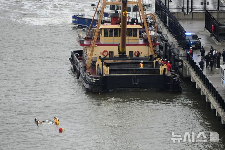 [뉴욕=AP/뉴시스] 10일(현지시간) 미국 뉴욕 허드슨 강 헬기 추락 현장에 바지선이 도착하고 있다. 2025.04.11.