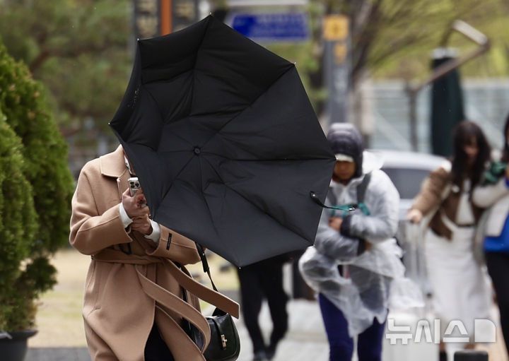 [서울=뉴시스] 김명년 기자 = 서울 시내에 강풍을 동반한 우박이 내린 13일 오후 서울 중구 세종대로 인도에서 한 시민의 우산이 바람에 뒤집히고 있다. 2025.04.13. kmn@newsis.com