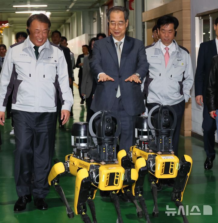 [광주=뉴시스] 조수정 기자 = 한덕수 대통령 권한대행 국무총리가 15일 광주 서구 기아오토랜드 광주공장에서 자동차산업 현장 시찰을 하며 보스턴 다이나믹스 로봇개 '스팟' 시연을 보고 있다. 왼쪽은 최준영 기아 사장, 오른쪽은 이항수 현대차·기아 부사장. (사진=국무총리실 제공) 2025.04.15. chocrystal@newsis.com