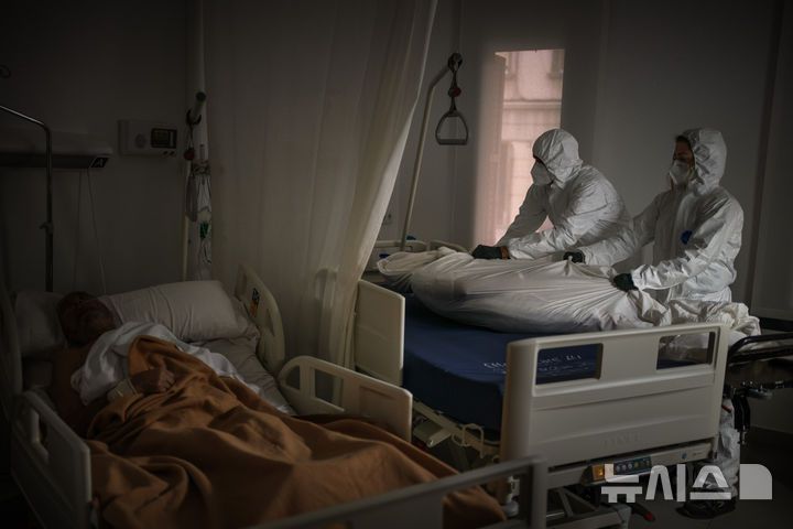 [AP/뉴시스] 한 요양원에서 방호복을 입은 장례식장 직원들이 숨진 노인의 시신을 수습하는 모습. 다. 사진은 기사 내용과 관련 없음.(사진=뉴시스 DB)
