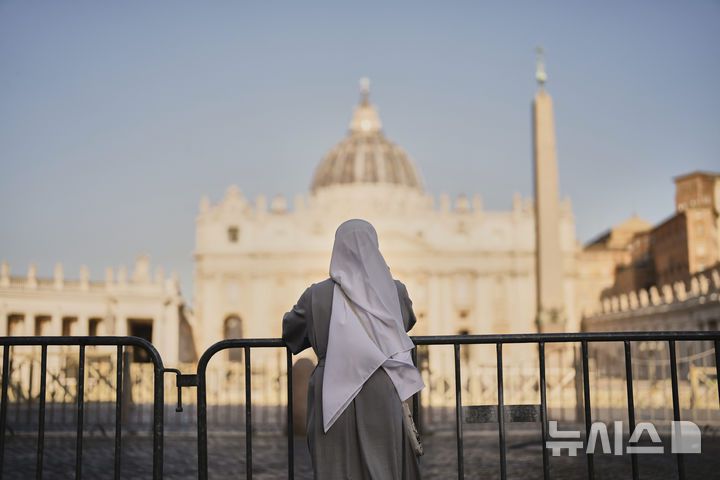 [바티칸시티=AP/뉴시스]한 수녀가 22일(현지 시간) 바티칸 성 베드로 광장에 서서 하루 전 선종한 프란치스코 교황을 추모하고 있다. 2025.04.23.
