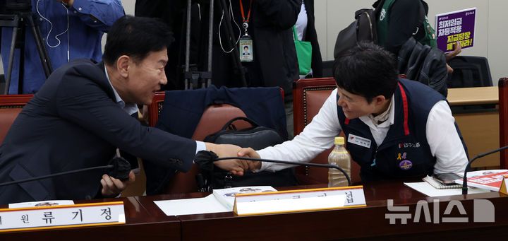 [세종=뉴시스] 강종민 기자 = 22일 세종시 정부세종청사에서 열린 최저임금위원회 제1차 전원회의에 앞서 류기정 사용자 위원과 이미선 근로자 위원이 악수하고 있다. 2025.04.22. ppkjm@newsis.com