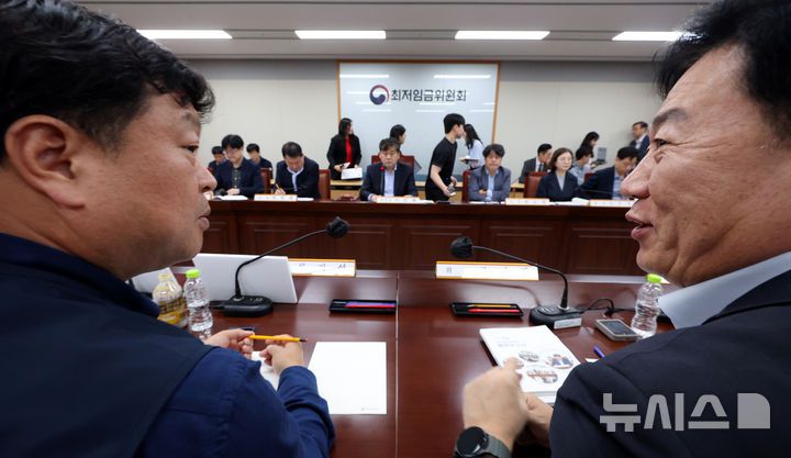 [세종=뉴시스] 강종민 기자 = 22일 세종시 정부세종청사에서 열린 최저임금위원회 제1차 전원회의에서 류기정 사용자 위원(오른쪽)과 류기섭 근로자 위원이 대화하며 미소 짓고 있다. 2025.04.22. ppkjm@newsis.com